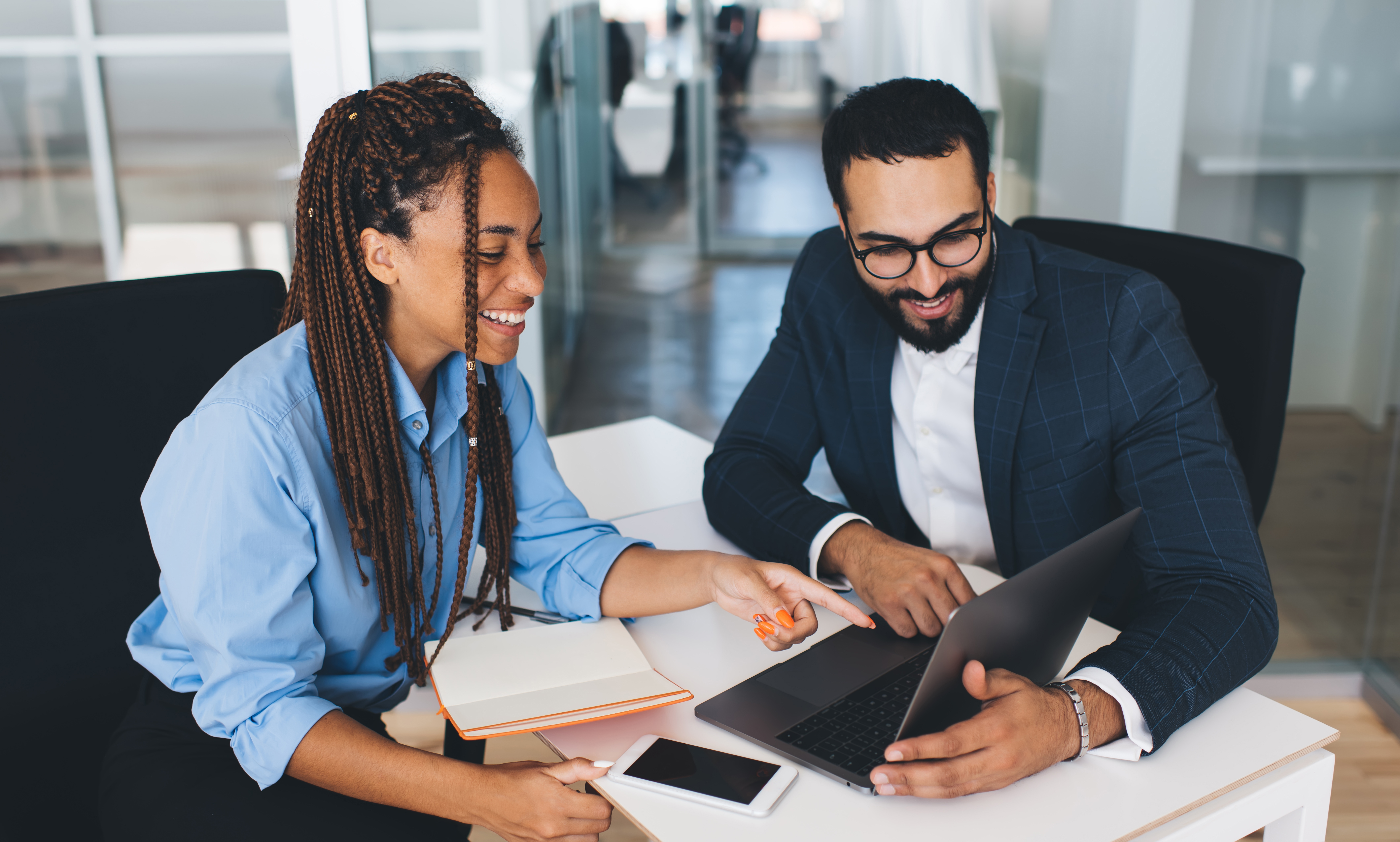 Friends comparing savings accounts on a computer