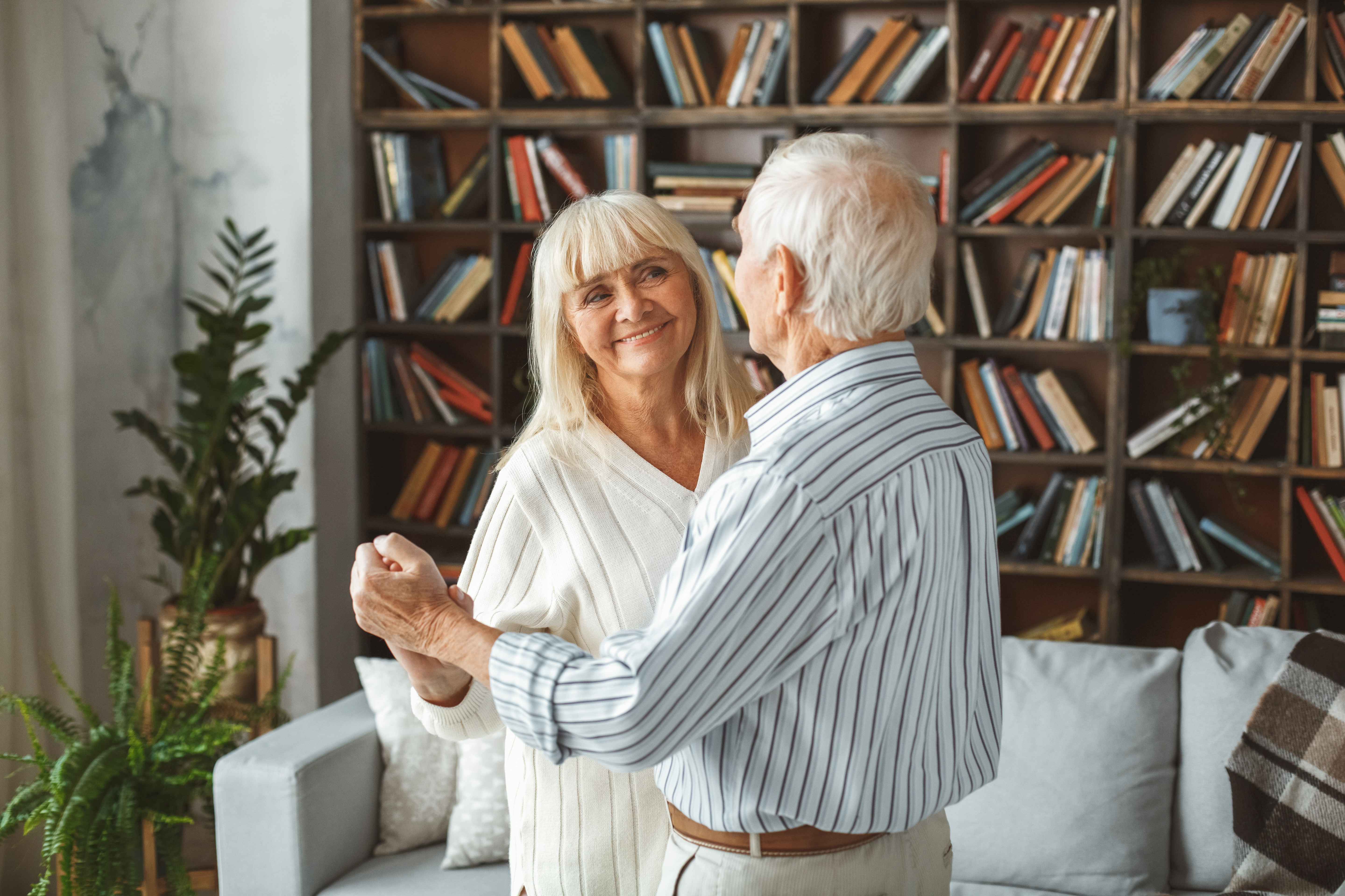 Retired couple dancing in their paid off home 