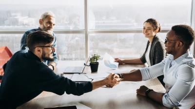 Group shaking hands after agreeing to a deal