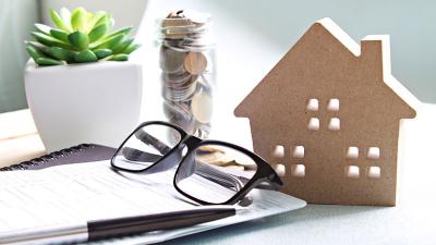 a wooden house next to a piece paper, a homebuyer is evaluating opening a Leader Bank home equity line of credit for renovations