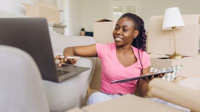 Woman at home on her laptop reviewing Leader Bank's FTHB checklist so she can become a homeowner