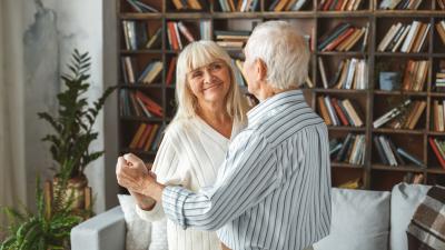 Retired couple dancing in their paid off home 